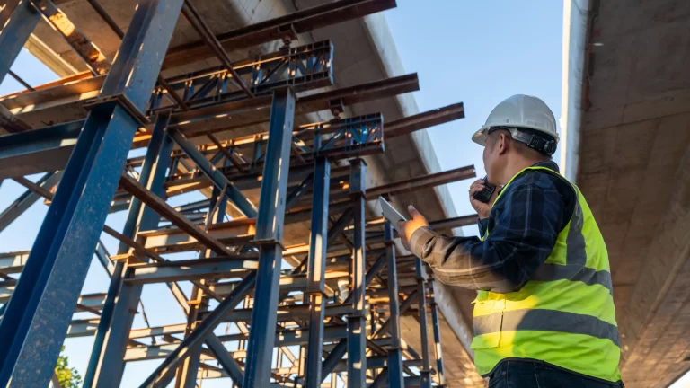 Man on construction site looking up at scaffolding